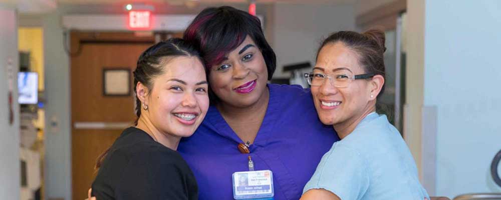 photo of three smiling Kaiser Permanente nurses